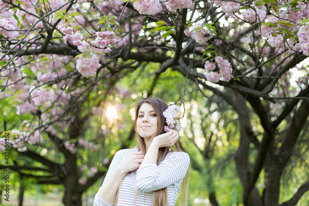girl near blooming sakura. Spring is now. Cherry blossoms. Sakura at dusk. portrait at sunset girl near blooming sakura. Spring is now. Cherry blossoms. Sakura at dusk. portrait at sunset