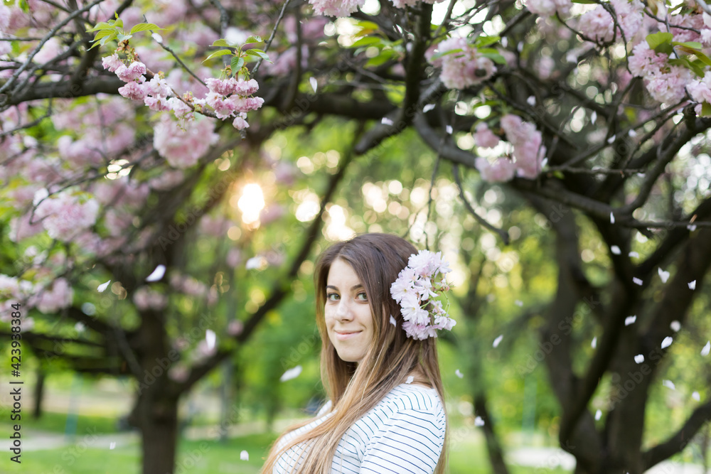 girl near blooming sakura. Spring is now. Cherry blossoms. Sakura at dusk. portrait at sunset