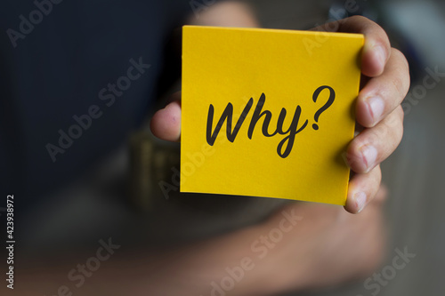 Cuadro en lienzo Hand holding an orange Paper with the word why - Why?, Business Concept
