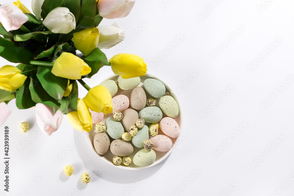 A bouquet of tulips, Easter eggs on a plate on white background. Beautiful Easter greeting card. A bouquet of tulips, Easter eggs on a plate on white background. Beautiful Easter greeting card.