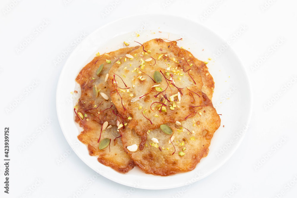 Creamy Soft Indian Mithai Dessert Mawa Malpua Coated With Cheeni Ki Chashni or Chaashni Is Made Of Wheat Aata Maida Suji Deep Fried In Shuddha Desi Ghee And Soaked In Sugar Syrup On White Background