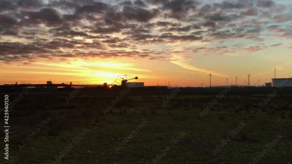 Industry under a beautiful sky. Sunrise behind a coal terminal stacker Industry under a beautiful sky. Sunrise behind a coal terminal stacker