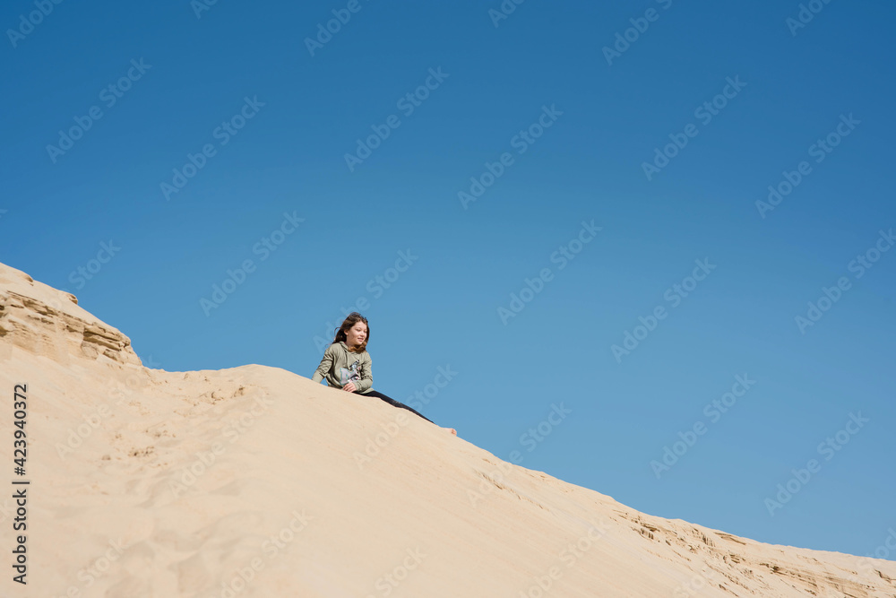 cute little girl playing in the sand dunes
