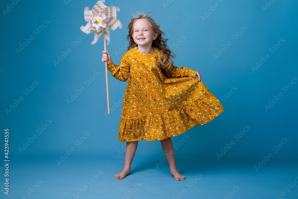 Fototapeta premium little girl holds a windmill in her hands