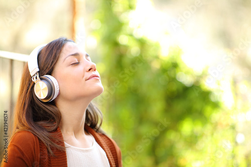 Relaxed woman with headphones breathing listening music