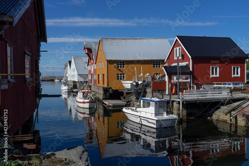 Fishing boats at the pier on a sunny day. Marina in a small fishing village with beautiful houses.