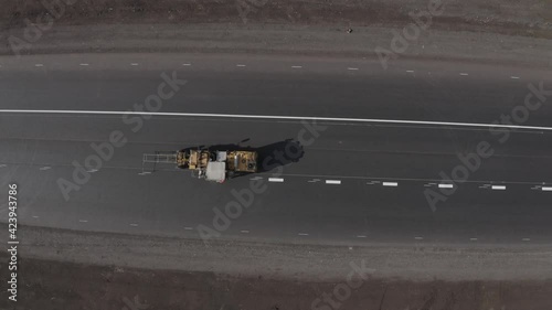 The copter flies over the top of the road and removes the marking of the asphalt