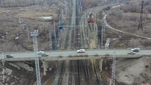 The rocopter flies over a bridge where cars are traveling, the bridge passes over the railway
