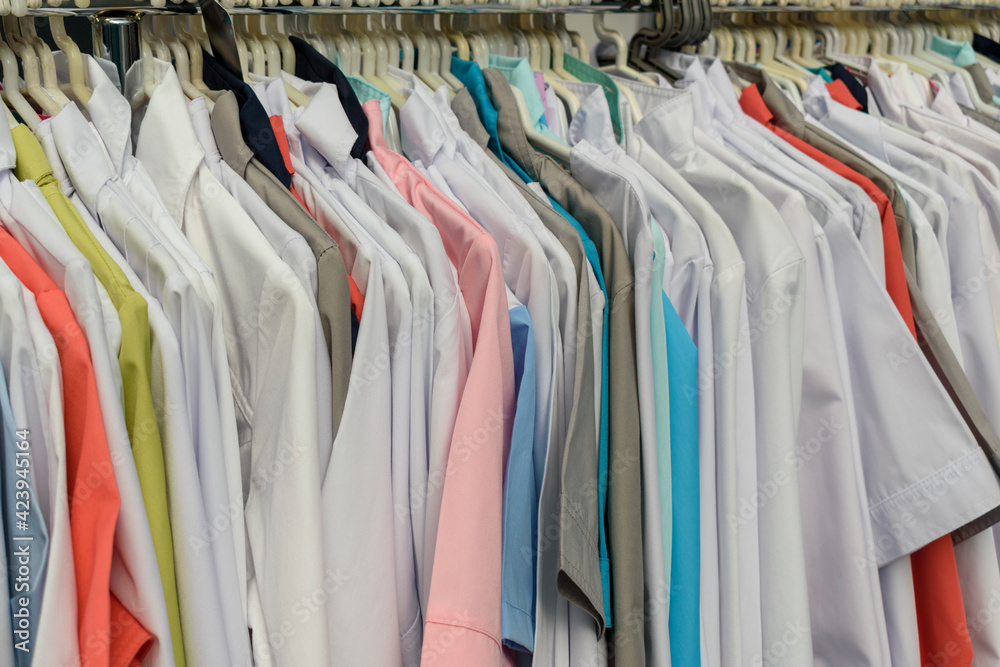 Hanger with white and colored clothes. The concept of overalls for doctors, hotel staff. Hanger with white and colored clothes. The concept of overalls for doctors, hotel staff.