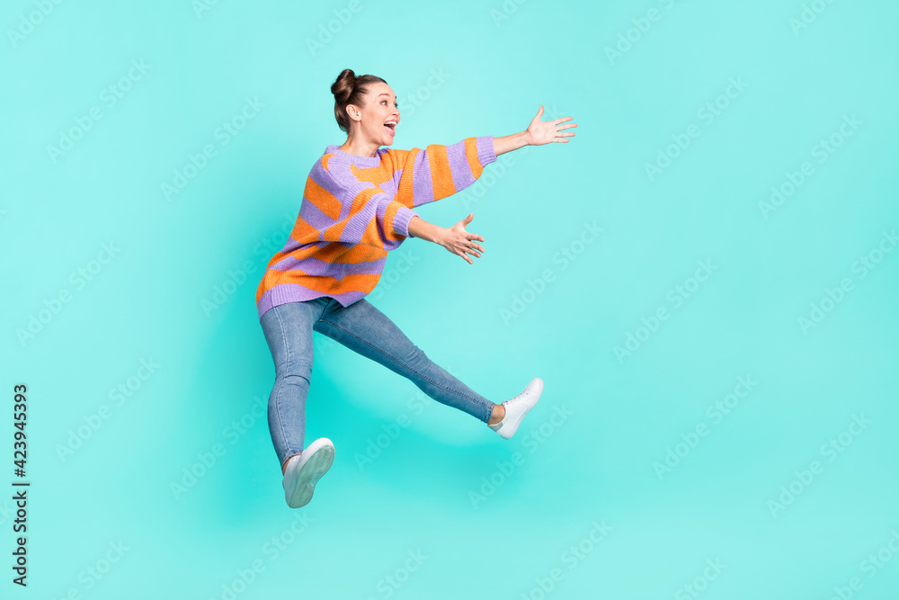 Full length body size view of pretty cheerful girl jumping hugging invisible friend isolated over bright teal turquoise color background