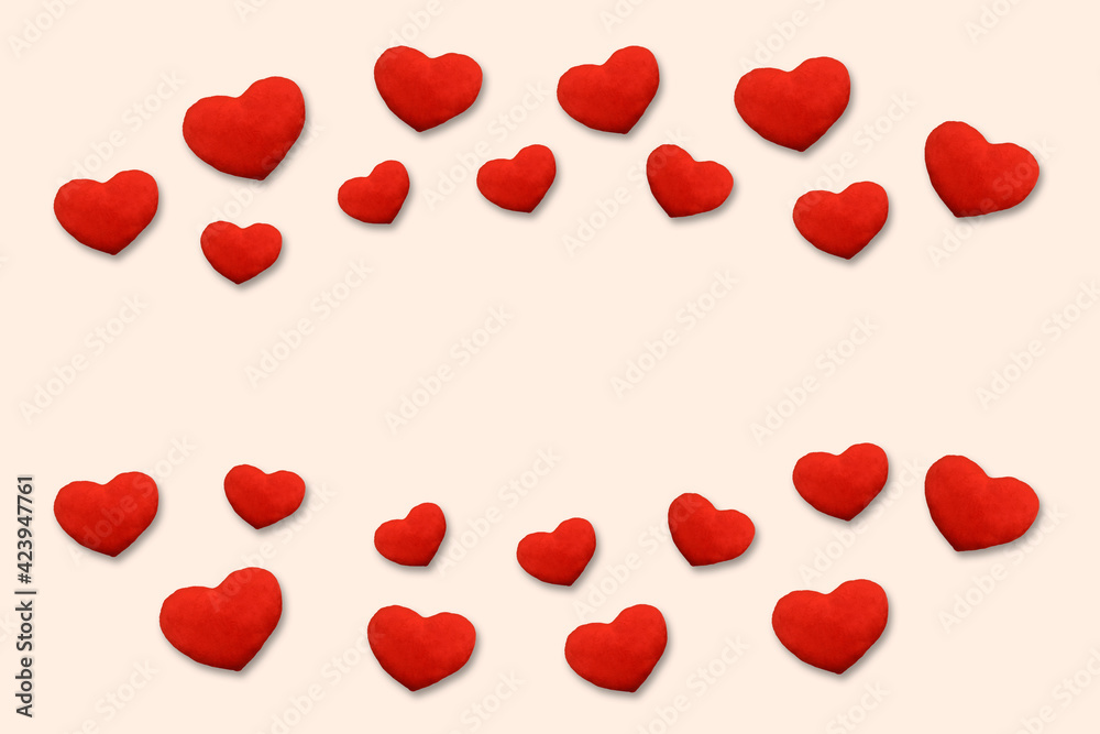 Red plush hearts on the light orange background with copy space