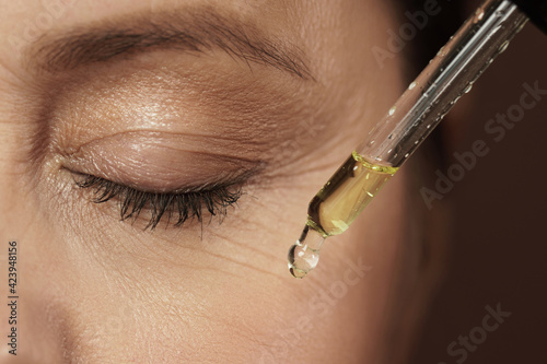 Female eye and dropper with rejuvenating serum photo