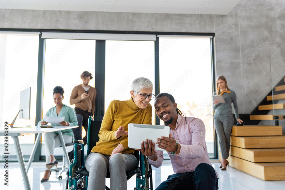Mature business woman with disability in wheelchair. Office inclusion concept Mature business woman with disability in wheelchair. Office inclusion concept