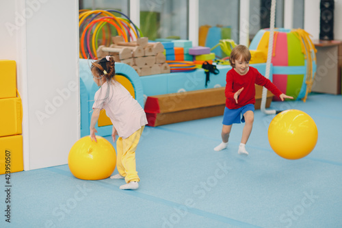 Kids doing exercises with big ball in gym at kindergarten or elementary school. Children sport and fitness concept. photo