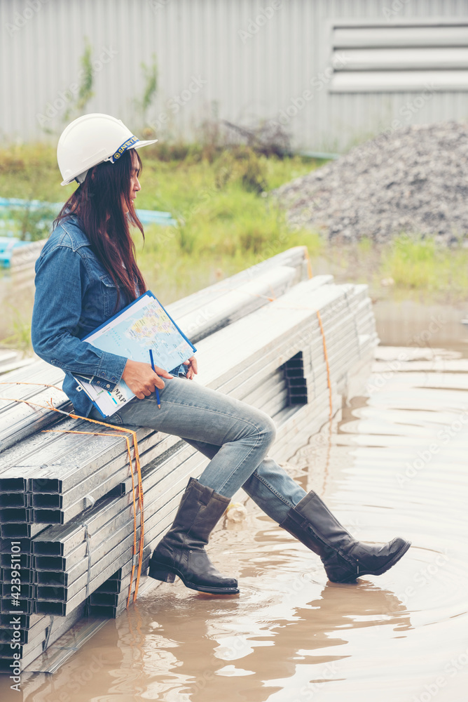 Woman construction engineer wear safety white hard hat at construction site industry worker. Female engineer worker civil engineering with hard hat safety helmet. Woman construction Engineer concept Woman construction engineer wear safety white hard hat at construction site industry worker. Female engineer worker civil engineering with hard hat safety helmet. Woman construction Engineer concept