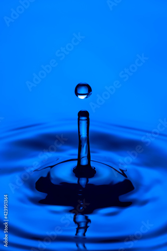Closeup Macro Shot of Blue Water Splash or Rain Drop Falling on Water Surface.