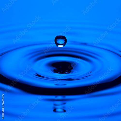 Macro Shot of Falling Blue Clear Water Droplet With Ripples.