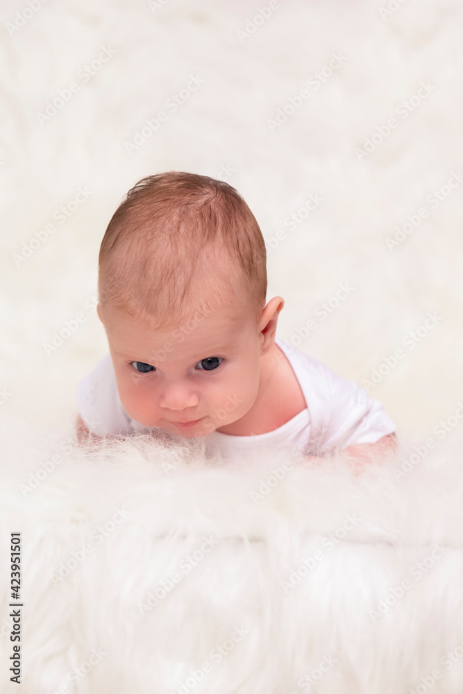 Newborn Baby Concepts. Portrait of Caucasian Newborn Boy Lying on Bed With Lifted Head. Macro Shoot. Newborn Baby Concepts. Portrait of Caucasian Newborn Boy Lying on Bed With Lifted Head. Macro Shoot.