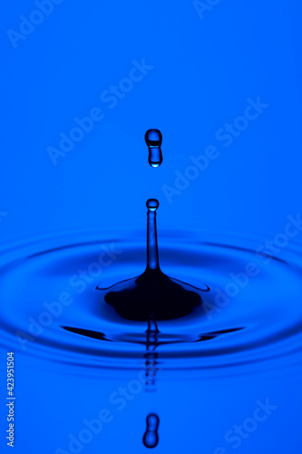Macro Shot of Blue Water Splashes of Different Shapes or Rain Drops Over Serene Water Surface.