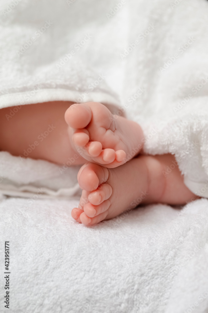 Infants Ideas and Concepts. Macro Close-up Image of a Four Week Old Baby Boy Crossed Feet Over White Towel. Infants Ideas and Concepts. Macro Close-up Image of a Four Week Old Baby Boy Crossed Feet Over White Towel.