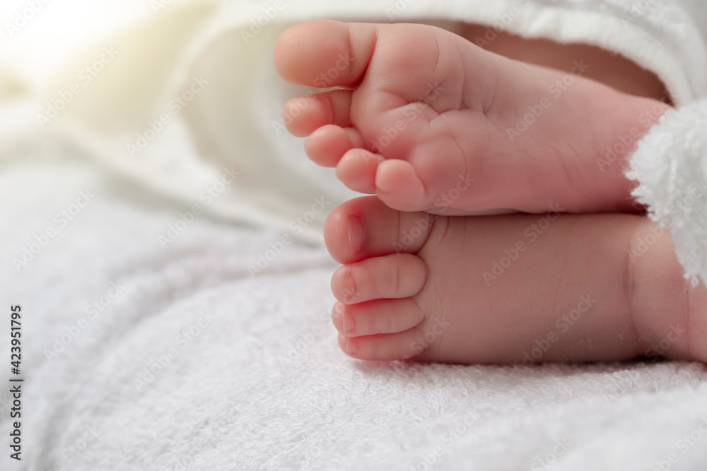 Macro Close-up Shot of a Four Week Old Baby Boy Crossed Feet Over White Towel with Added Sunflares. Macro Close-up Shot of a Four Week Old Baby Boy Crossed Feet Over White Towel with Added Sunflares.