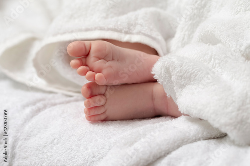 Macro Close-up Shot of a  Four Week Old Baby Boy Crossed Feet Over White Towel. © danmorgan12