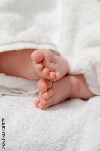 Infants Ideas and Concepts. Macro Close-up Image of a  Four Week Old Baby Boy Crossed Feet Over White Towel. © danmorgan12
