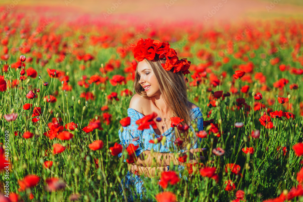 Beautiful young woman walks in a field with poppy flowers at sunset. Beautiful young woman walks in a field with poppy flowers at sunset.