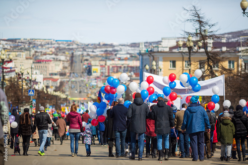 People with banners and balloons walk down the street during a May Day demonstration. Magadan, Magadan Region, Far East of Russia.