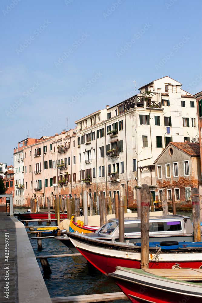 Beautiful view on Venice canal with colorful boats and old buildings in Italy in sunny day