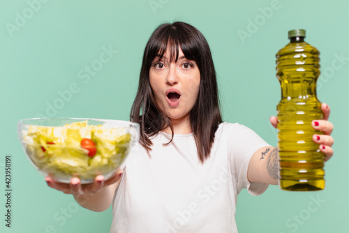 young pretty curvy woman scared expression and holding a salad photo