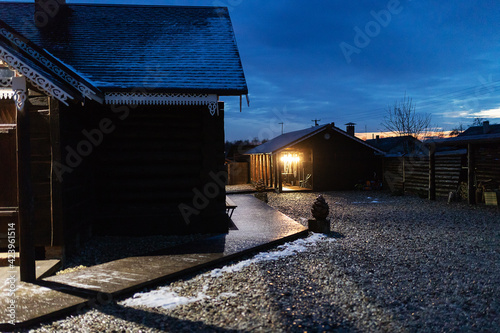 beautiful wooden hut. night illumination from lanterns illuminates the courtyard of a private house