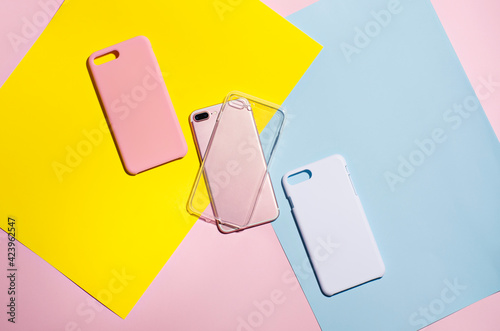 Set of three iPhone cases on bright background, phone case mock up, smart phone on a pink, blue and yellow background. three types of phone cases