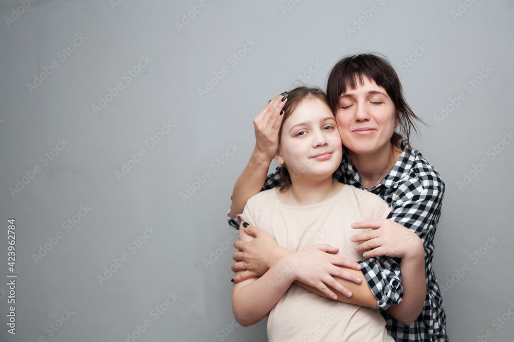 Woman in plaid shirt embracing her daughter Woman in plaid shirt embracing her daughter