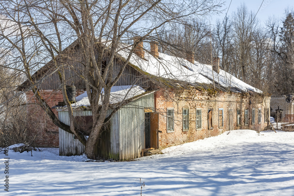 Part of the ruined facade of an abandoned old stone building at daytime