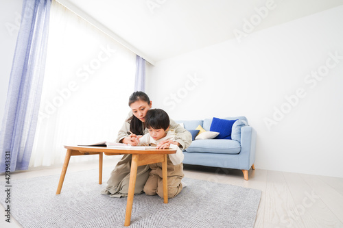 家でお母さんと一緒に勉強をする男の子