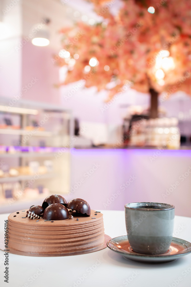 A cup of coffee against the blurry background of a restaurant bokeh.