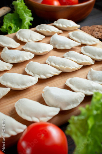 homemade natural farm dumplings and dumplings on the table with vegetables and herbs.