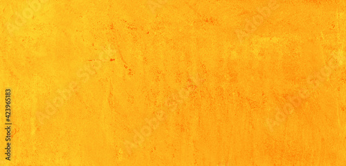 Yellow speckled hand-painted illustration texture design of old distressed vintage grunge concrete with orange stains. damaged textured abstract washed cement backdrop as web banner background.