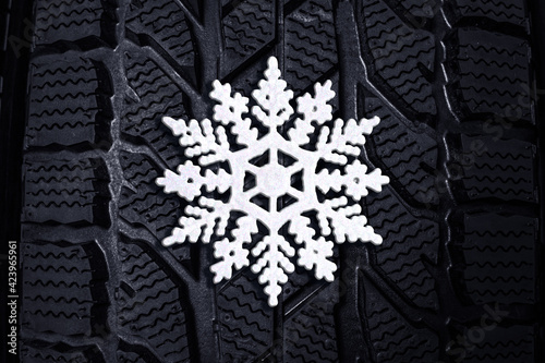 Winter tire with snowflake as background, closeup