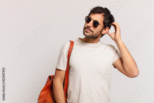 young indian traveler man doubting or uncertain expression photo