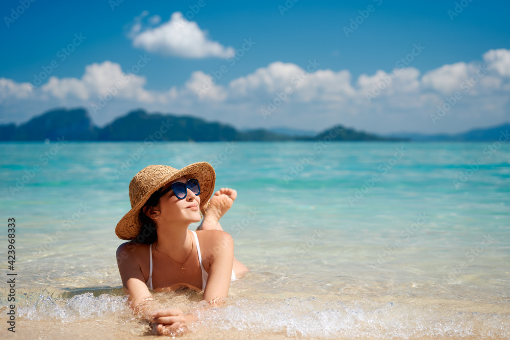 Portrait of a sensual young female in white bikini enjoying warm tropical ocean water with copy space.