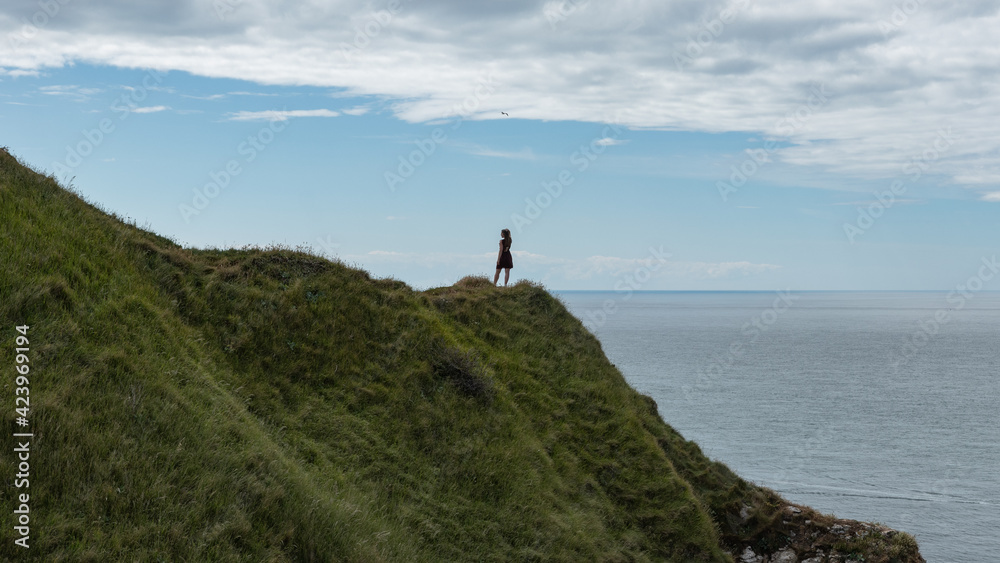 Femme posant sur une falaise