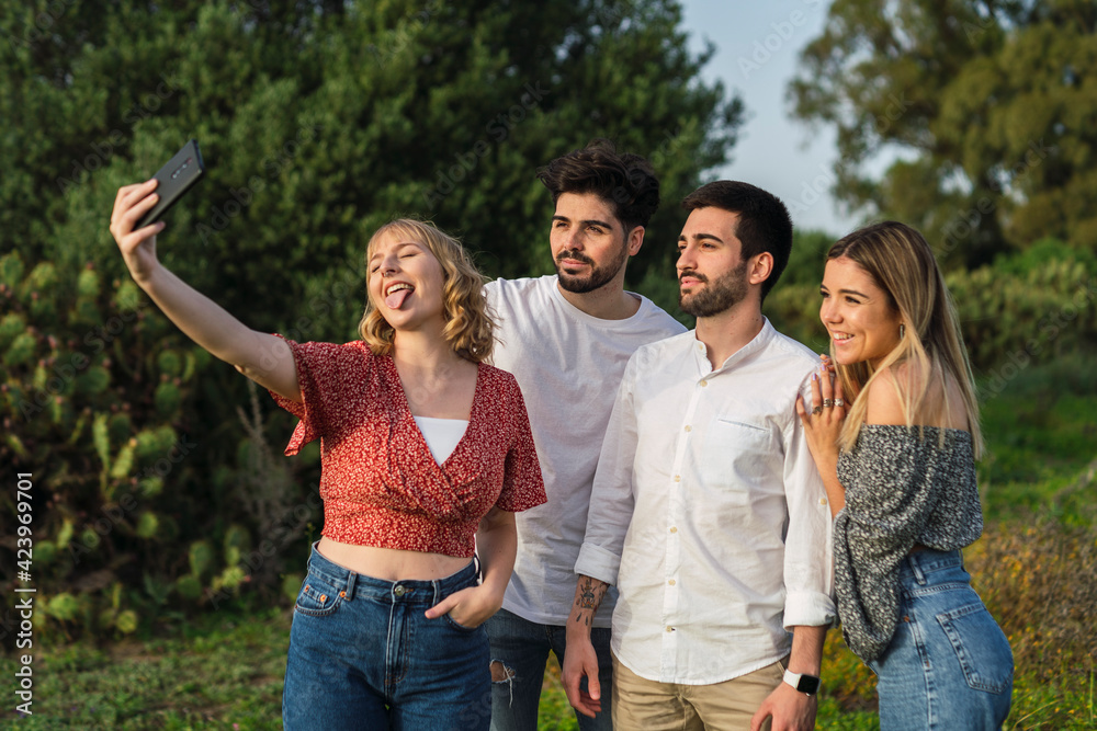 Grupo de amigos disfrutando de zona verde en primavera tomando selfies Grupo de amigos disfrutando de zona verde en primavera tomando selfies