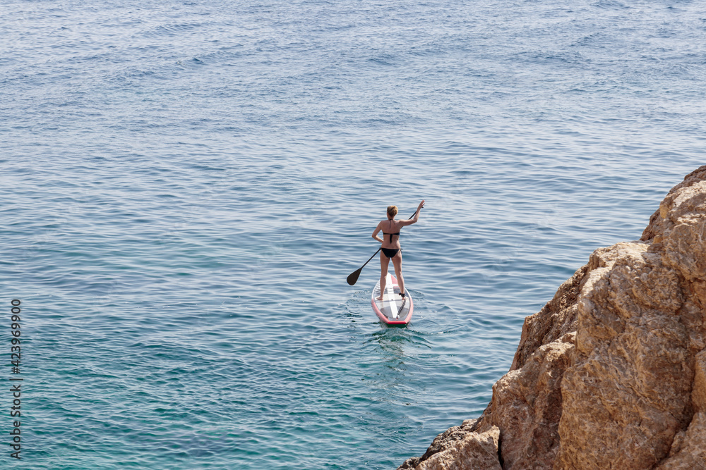 people paddle surfing on the costa brava in girona on a summer day in a blue sea