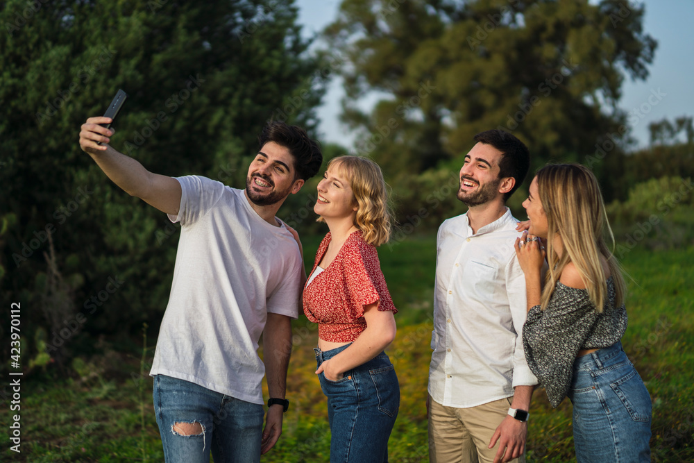 Grupo de amigos disfrutando de zona verde en primavera tomando selfies Grupo de amigos disfrutando de zona verde en primavera tomando selfies