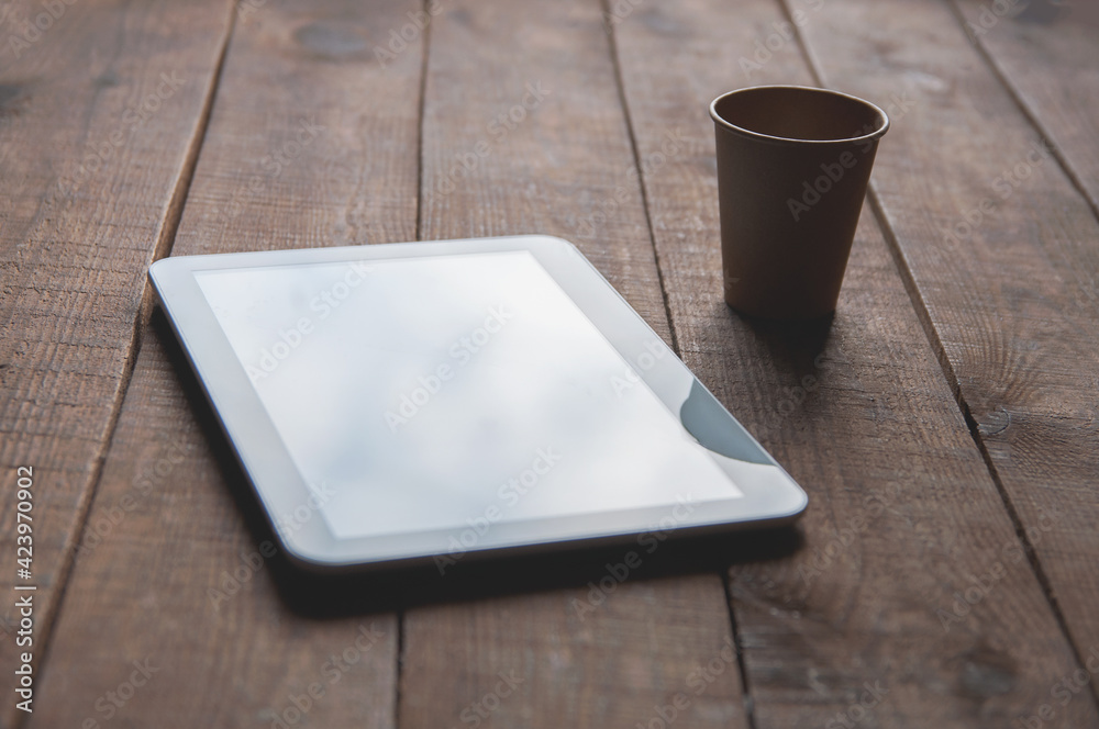 Modern office workspace with tablet pc on the table and a disposable cup of coffee. Modern office workspace with tablet pc on the table and a disposable cup of coffee.