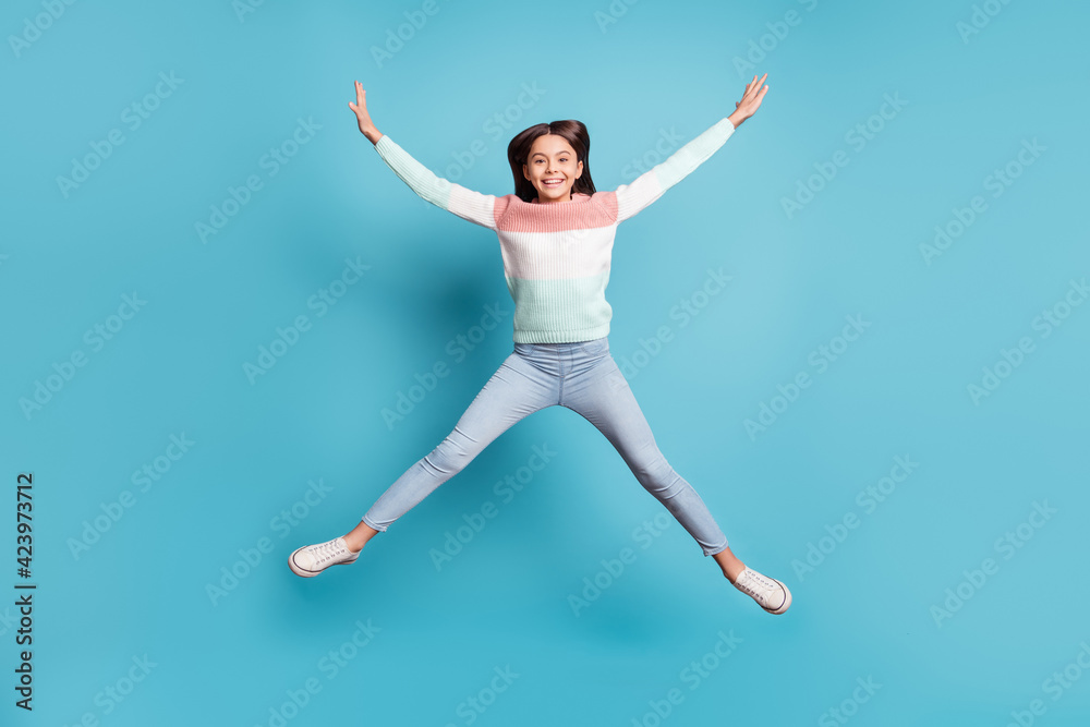 Full body photo of young cheerful girl happy positive smile have fun jump up isolated over blue color background