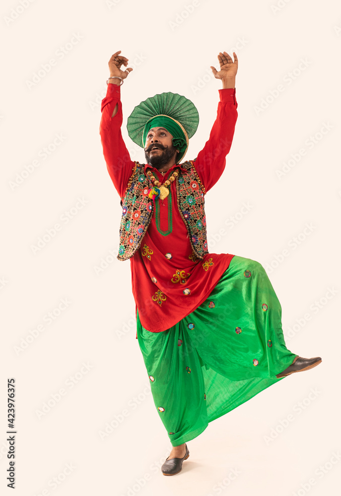A Bhangra dancer illustrating a dance step with hands in the air.	
