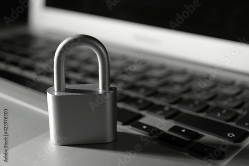 Metal lock on laptop, closeup. Cyber security concept